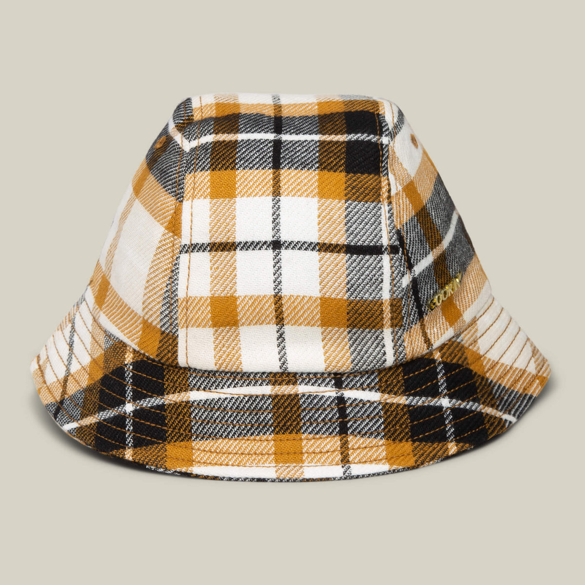 The Goorin Bros. Bespoke Wordmark Bucket hat in AMBER features a plaid pattern in yellow, black, and white, displayed against a plain beige background.