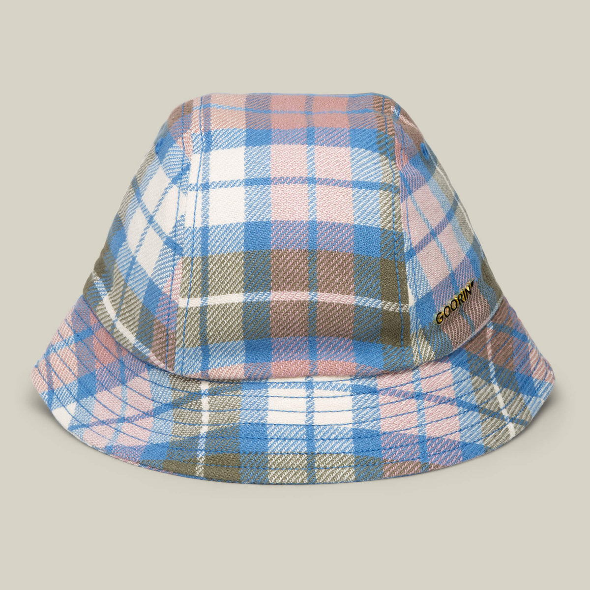 The Bespoke Wordmark Bucket by Goorin Bros. in CRUISE features a plaid pattern in blue, pink, white, and brown checks with a metallic CORDUROY label on the side and a subtle GOORIN wordmark for added style.