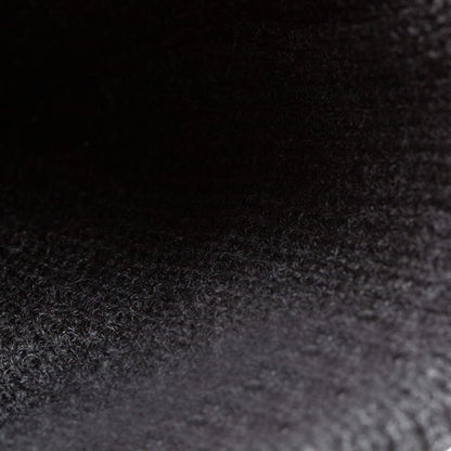 Close-up of The Beware Beanie by Goorin Bros., showing its dark, heavyweight knit material with a textured and slightly fibrous surface under low lighting.