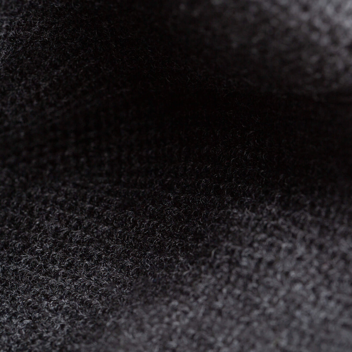 Close-up of The Deadly Beanie by Goorin Bros.—a dark, textured knit with a slightly fuzzy surface and visible weave, making it perfect for winter.