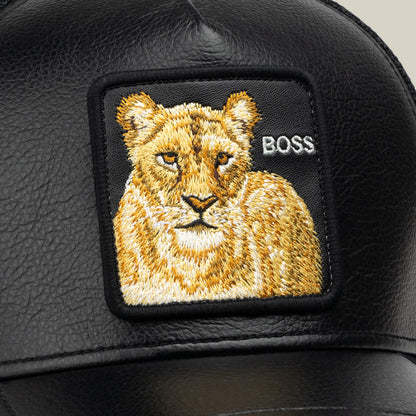 The Goorin Bros. Faux Leather Lioness is a black faux-leather trucker hat featuring a stitched lioness patch with “BOSS” embroidered in white on the right side of the patch, while breathable mesh ensures both comfort and style.