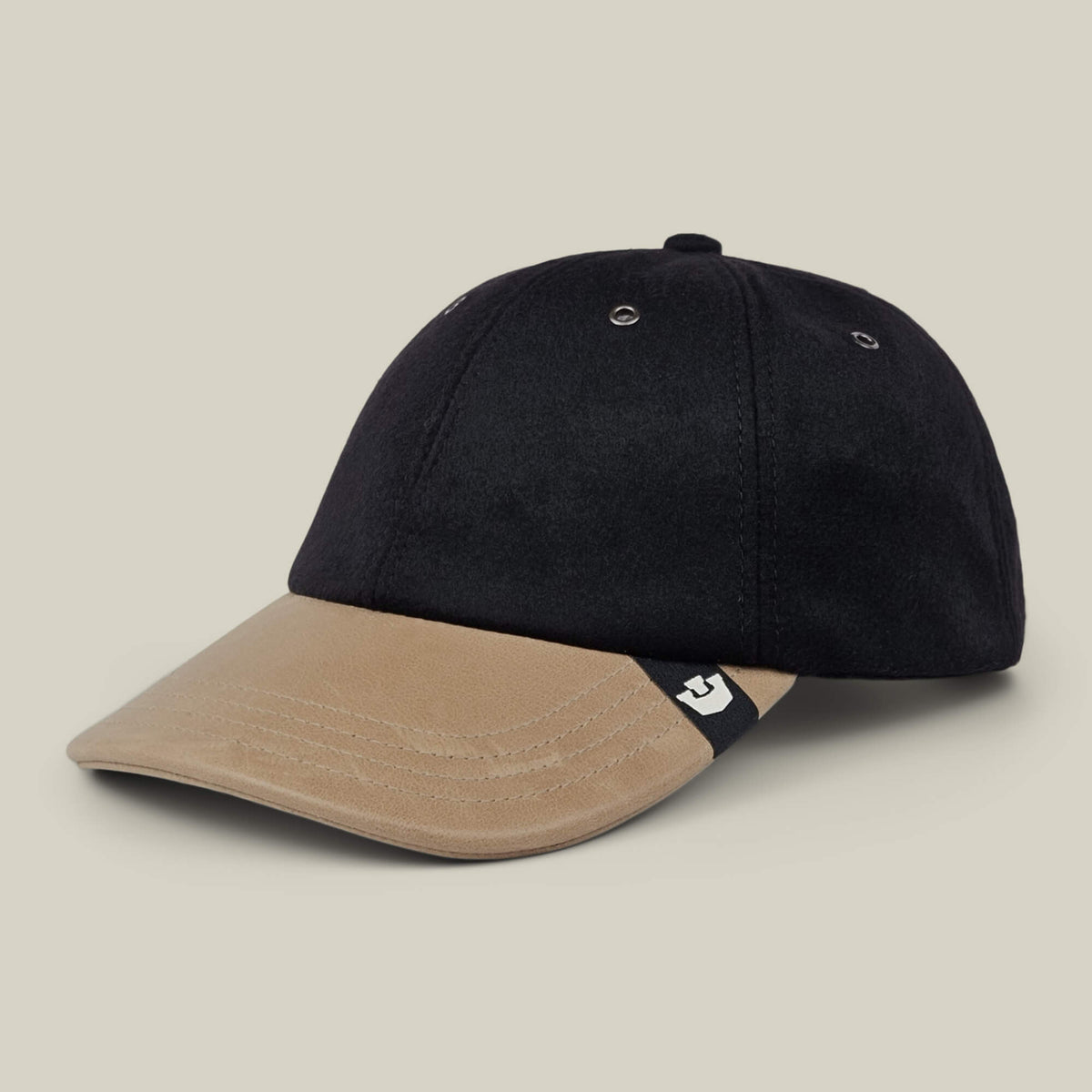 Sure! Here’s the sentence rewritten using your product data: The Goorin Bros. Bixby is a handmade baseball cap from New Jersey, featuring a black crown, tan brim, and a small black and white tag on the left side of the brim.