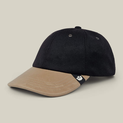 Sure! Here’s the sentence rewritten using your product data: The Goorin Bros. Bixby is a handmade baseball cap from New Jersey, featuring a black crown, tan brim, and a small black and white tag on the left side of the brim.