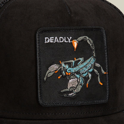 Close-up of the Suede Scorpion trucker hat by Goorin Bros., showcasing a black patch with an embroidered scorpion and the word DEADLY in white above it. The hat features breathable mesh panels for both comfort and style.