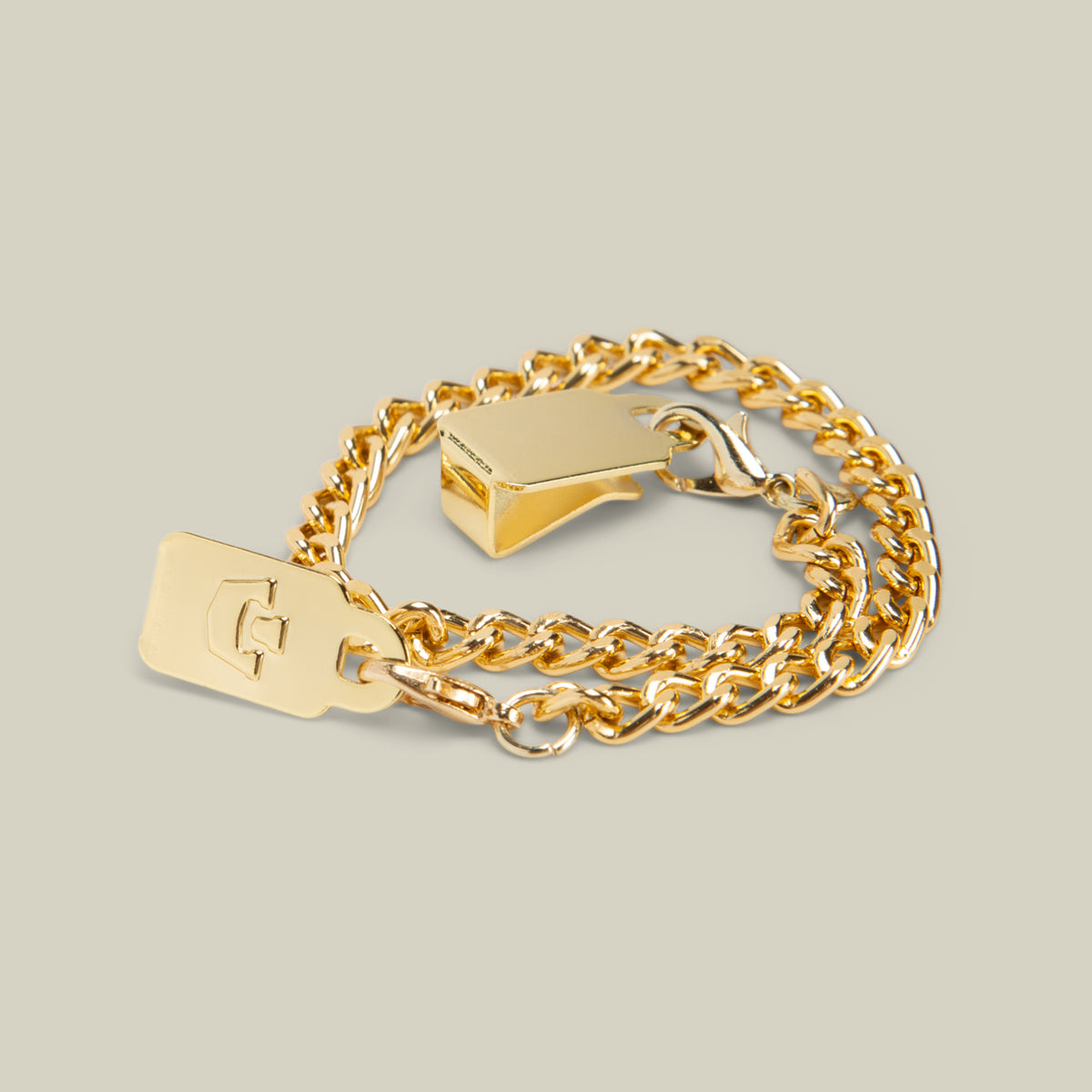 A Goorin Bros. Mini CapLoc Chain gold double clip chain bracelet featuring a rectangular tag engraved with a letter and a geometric clasp, displayed on a neutral background.