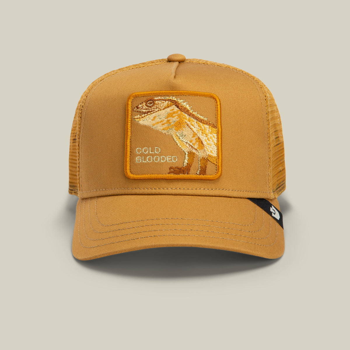 The Circle of Life - Cold Blooded trucker hat by Goorin Bros. features a mustard yellow design with a mesh back and a front patch embroidered with a bearded lizard and the words “COLD BLOODED.”.