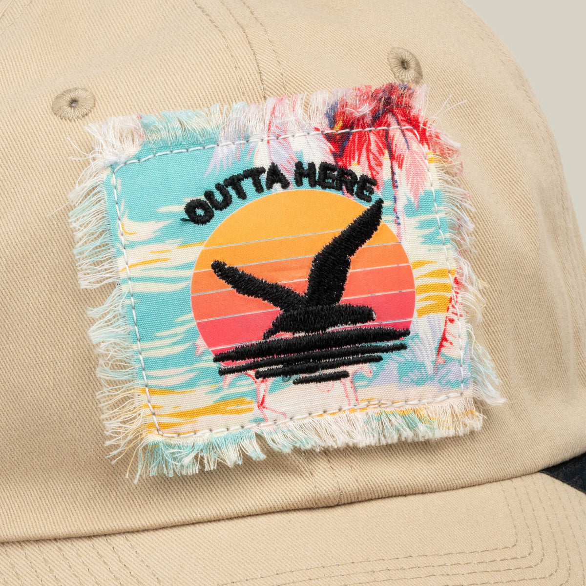 Beige “GTFO” hat by Goorin Bros., featuring a frayed patch with a sunset, palm trees, and two black birds in flight beneath the words OUTTA HERE—a relaxed design inspired by S.O.S. Island mess hall tales and adventure.