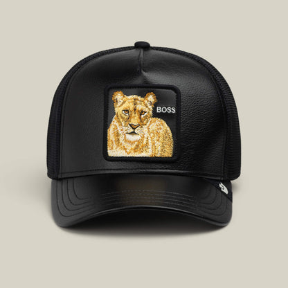 The Goorin Bros. Faux Leather Lioness trucker hat features a black faux-leather front, a breathable mesh back, and a bold front patch with an embroidered lioness and the word “BOSS.”.