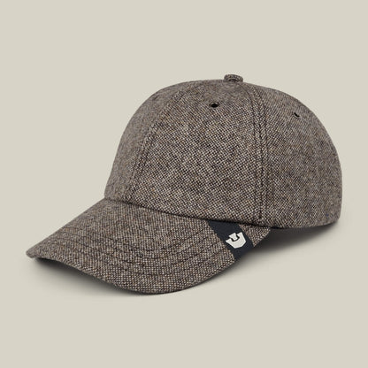 The Goorin Bros. Valmont is a brown textured wool baseball cap with a curved brim and a small black tag featuring a white logo, made in the USA and shown on a plain beige background.