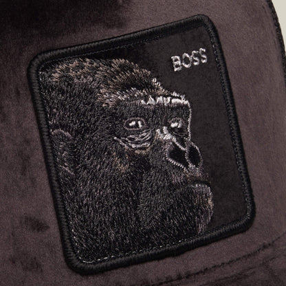 A black embroidered patch featuring a gorilla’s face and the word “BOSS” in white text is stitched onto a dark fabric background, creating a bold accent for any breathable mesh hat or polyester trucker—introducing the Velour Boss by Goorin Bros.