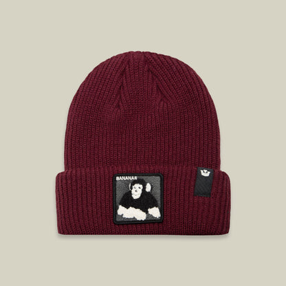 Stay warm and stylish with the Goorin Bros. Double Stuffed - Bananas Beanie, a maroon rib knit winter hat featuring a rectangular black patch on the front cuff with a playful white and black cartoon gorilla and the text “BANANAS.”.