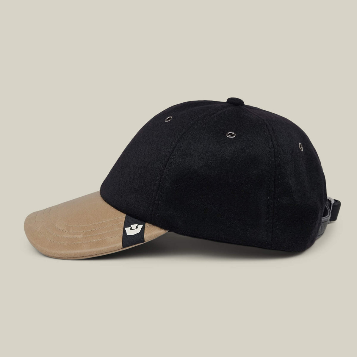 The Goorin Bros. Bixby is a handmade black baseball cap with a tan brim, crafted in New Jersey and featuring a small black tag with a white logo, shown on a plain light background.