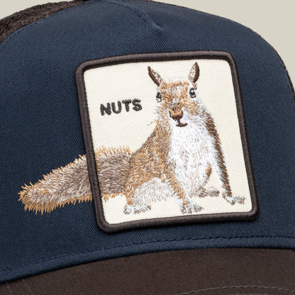 Close-up of the Goorin Bros. Over the Line Squirrel hat in navy, showcasing an embroidered patch with a squirrel and the word “NUTS” on the front, designed with an adjustable fit for comfort.