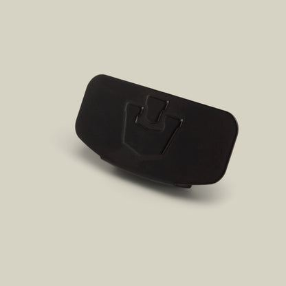 A black plastic Castle CapLoc by Goorin Bros., featuring a raised, U-shaped emblem on the front, photographed against a plain light beige background—perfect as a stylish hat accessory.