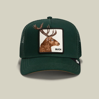 The Over the Line Buck trucker hat by Goorin Bros. is crafted from a dark green polyester-cotton blend and features breathable mesh panels, as well as a front patch with an embroidered brown buck head and bold black “BUCK” lettering.