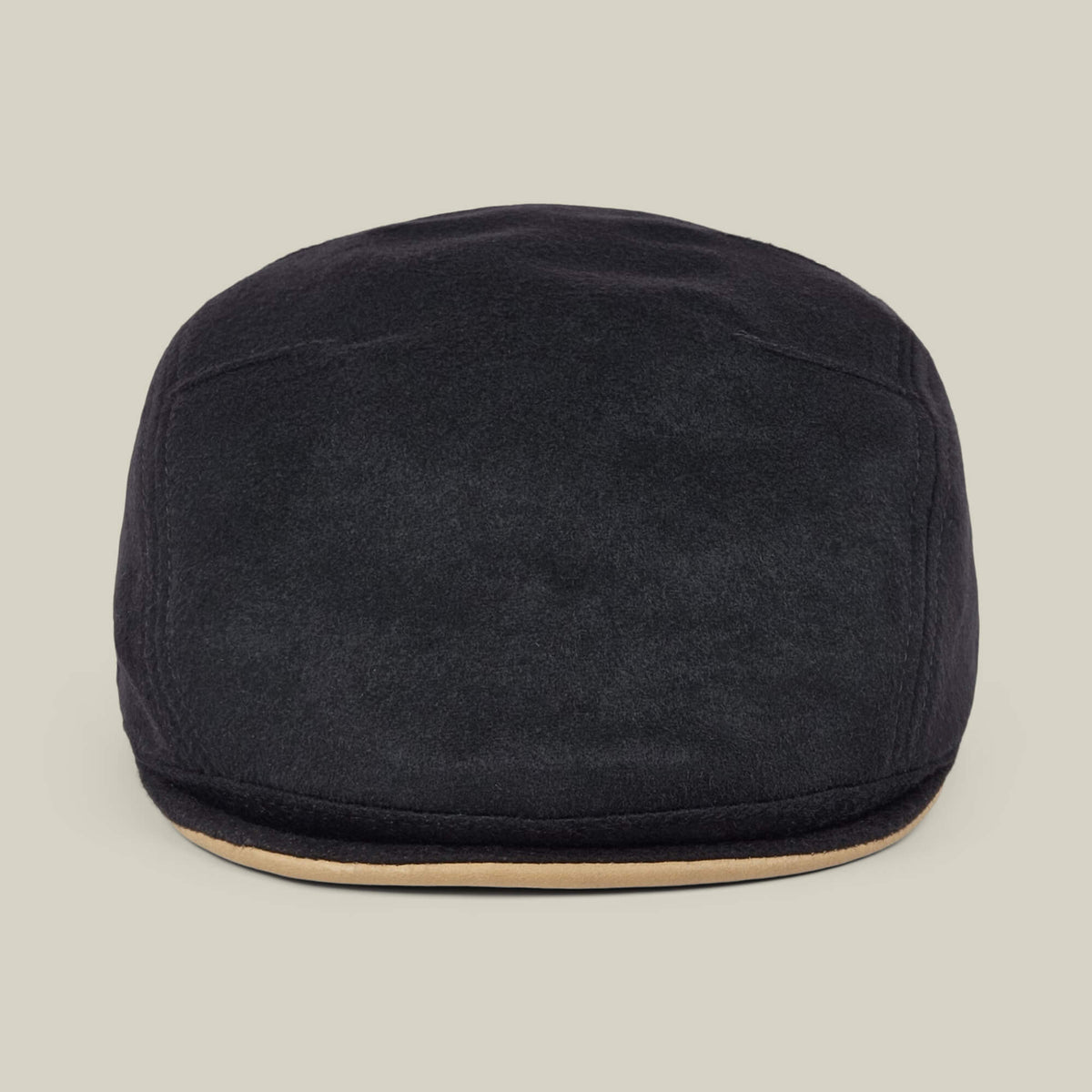 The Goorin Bros. Cornerstone is a black wool flat cap featuring a slightly curved brim and a beige accent along the edge, handmade in New Jersey and displayed against a plain light background.