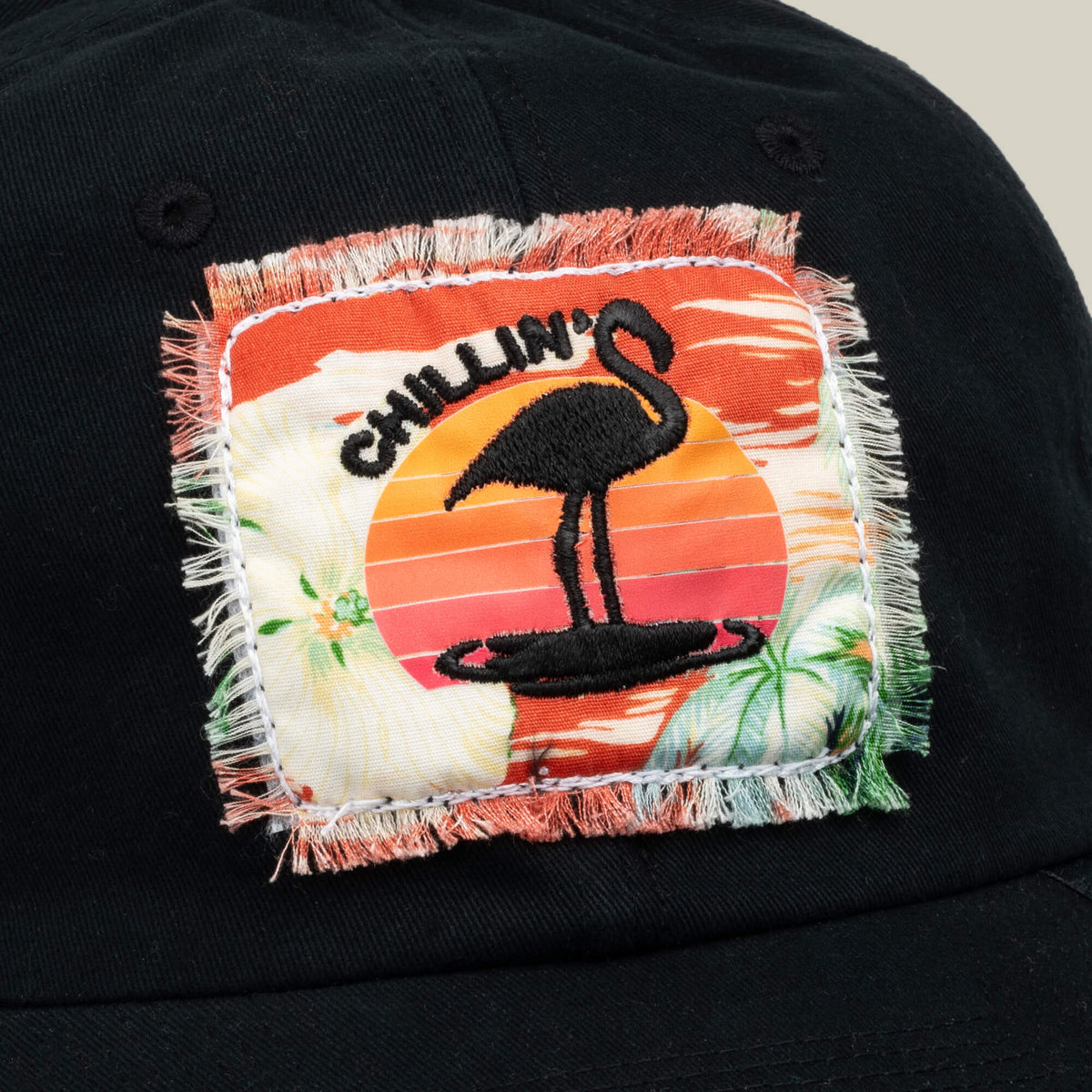 Black cap by Goorin Bros. featuring a colorful patch with a flamingo silhouette, tropical background, and the word “CHILLIN” above the bird—the PTO is the perfect accessory to capture S.O.S. Island Spa’s laid-back vibe and pain-forward wellness philosophy.
