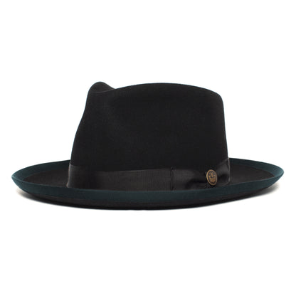 The Goorin Bros. River Gray is a black wide brim fedora hat, crafted from American-made merino wool, featuring a striking dark green brim edge, a sleek black band, and a small round metal emblem on the side, shown on a white background.