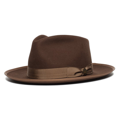 The River Gray by Goorin Bros. is a wide brim fedora in a rich brown, featuring a matching ribbon band and a small decorative pin on the side. Expertly crafted from merino wool, this American-made accessory blends classic style with lasting comfort—perfect for any wardrobe.