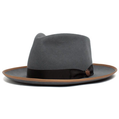 The River Gray by Goorin Bros. is an American-made wide brim fedora crafted from premium merino wool, featuring a brown edge trim and a black band with a small round emblem.